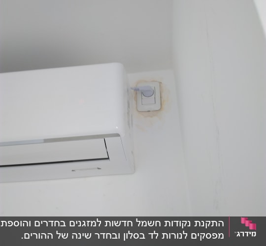 שקע חשמל עם חוט מחובר ליד מזגן